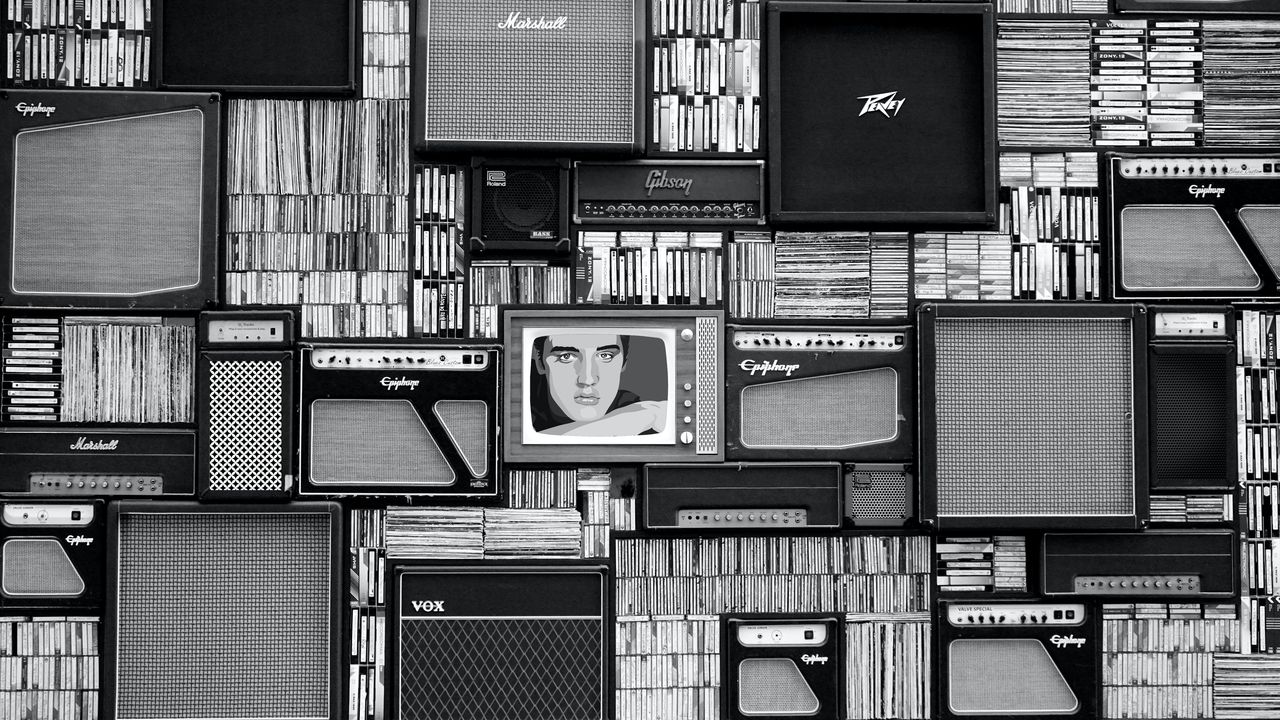 Pared de amplificadores y cintas de casete con una televisión antigua en el centro, en blanco y negro