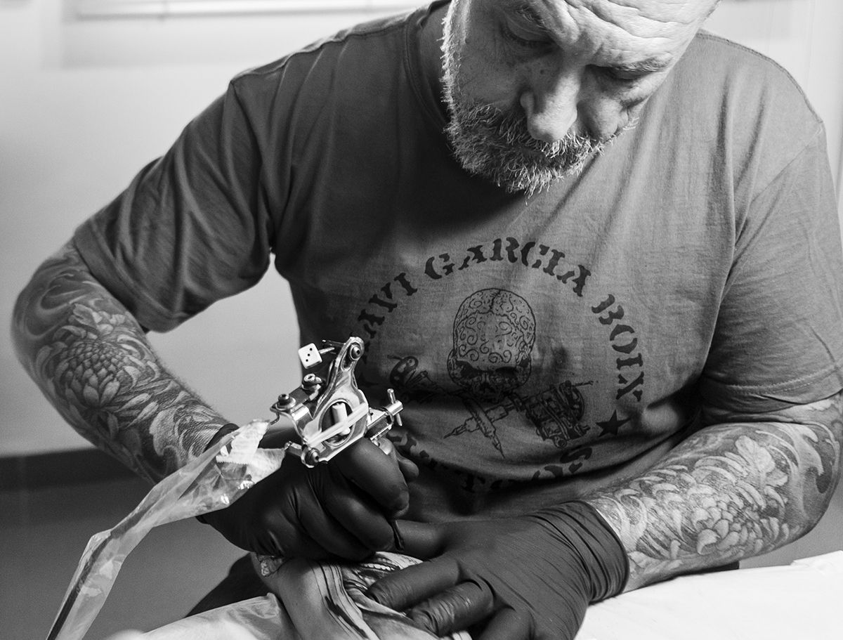 Xavi García Boix tatuando con una máquina de bobinas, en blanco y negro
