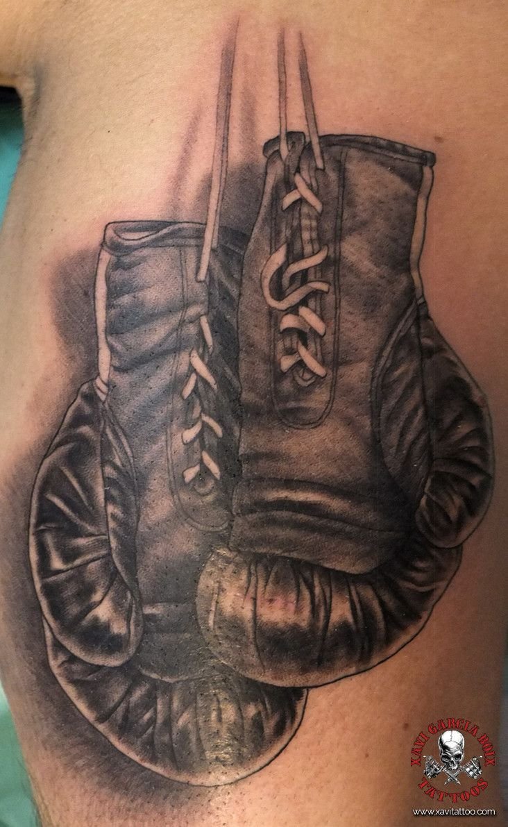 Tatuaje realista: guantes de boxeo colgados de sus cordones, por Xavi García Boix en Valencia