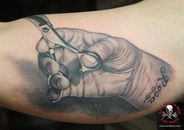 Tatuaje realista: mano cerrada con unas tijeras de peluquero, por Xavi García Boix en Valencia