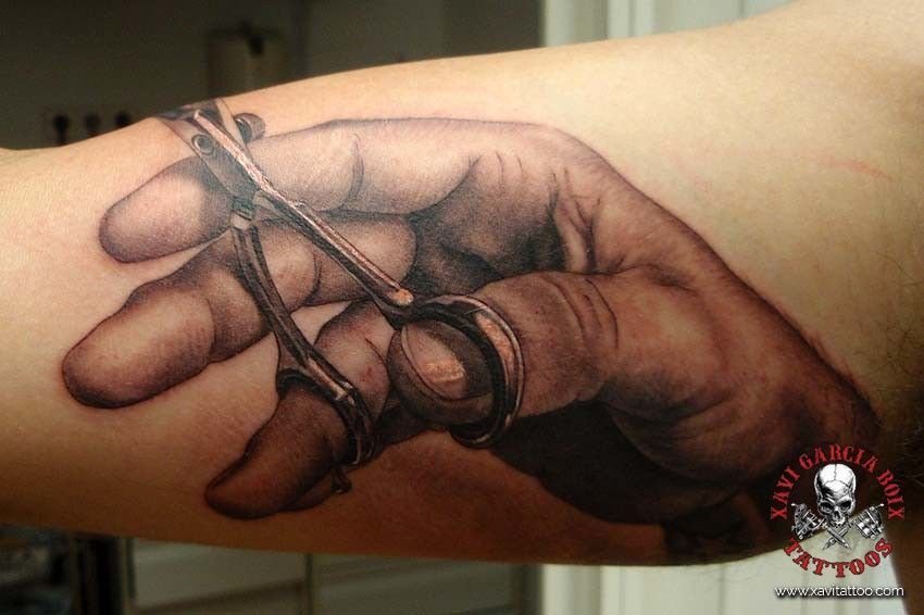 Tatuaje realista: mano sujetando unas tijeras de peluquero, por Xavi García Boix en Valencia